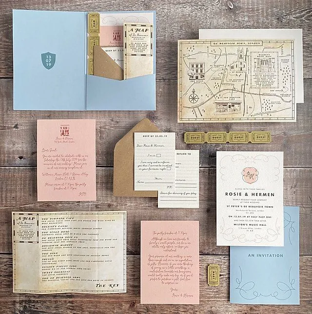 Flat lay of blue and pink wedding stationery suite with a map and RSVP cards