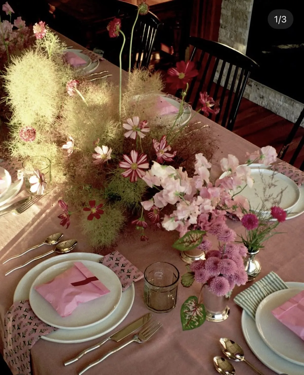 Overhead view of a pink tablescape with cosmos flowers and pink favor envelopes