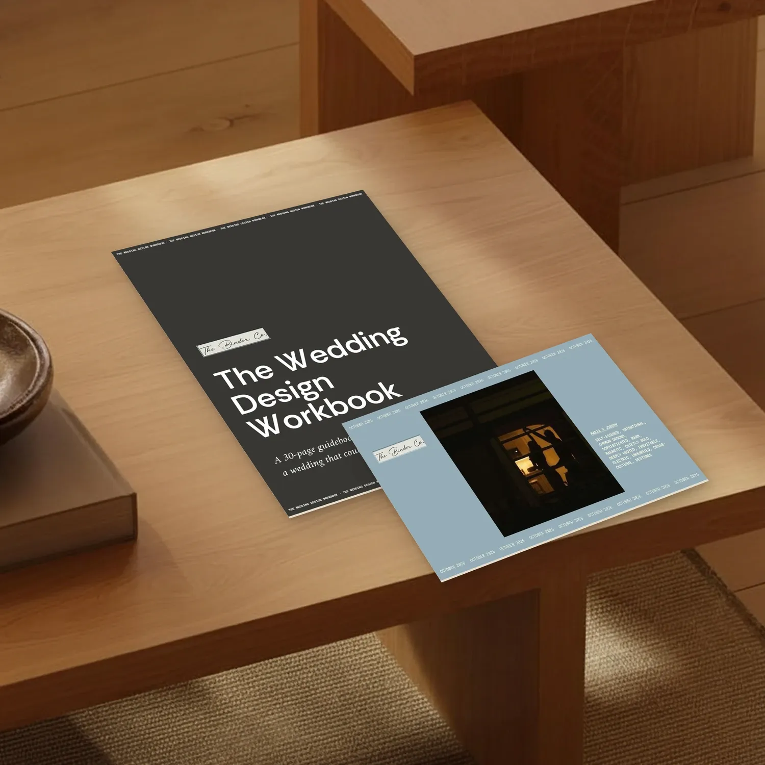 The Wedding Design Workbook and The Binder resting on a sunlit wooden side table